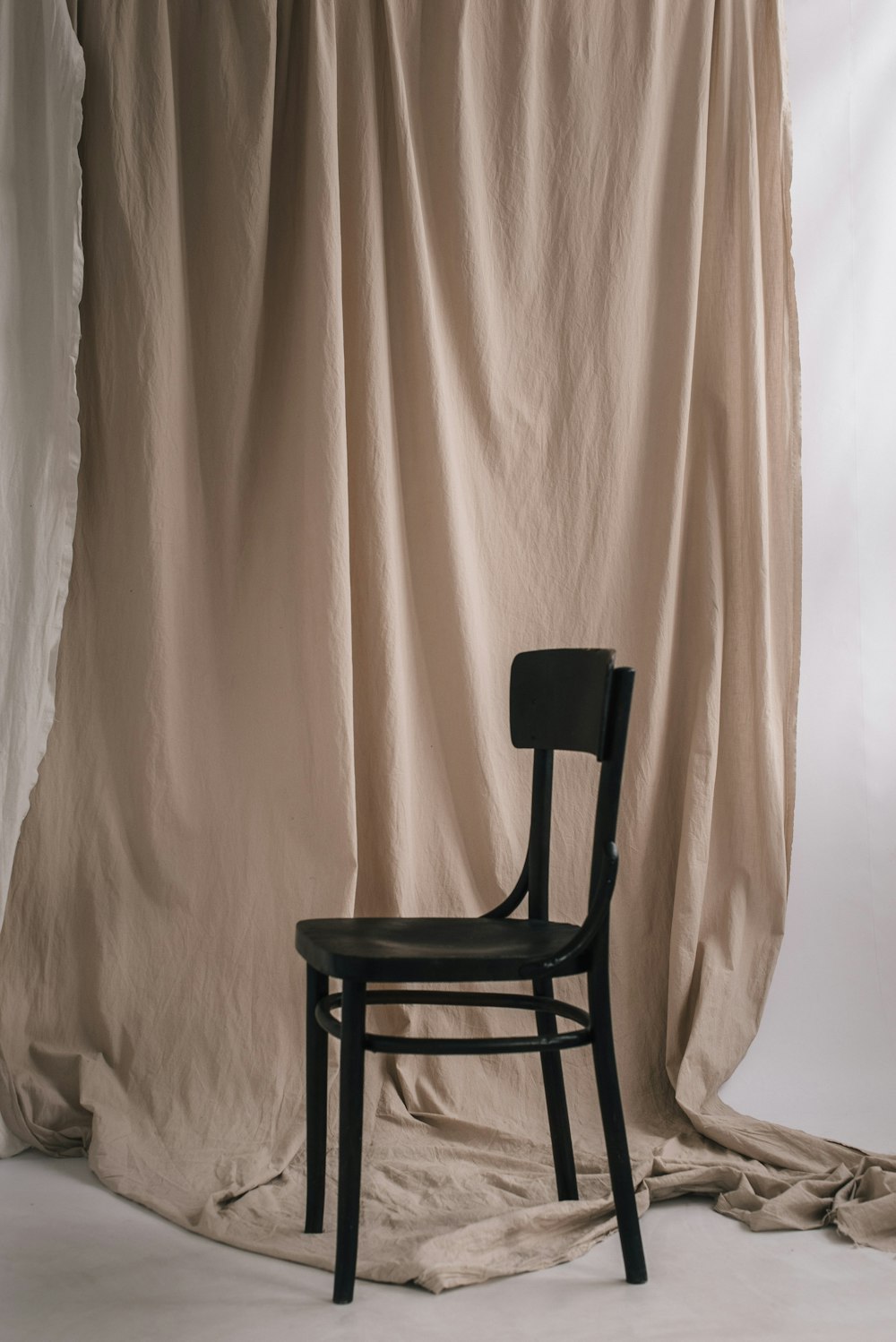 black wooden chair beside white curtain