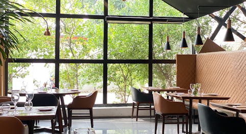 beautiful restaurant setting with a view of trees through large clean window panes 