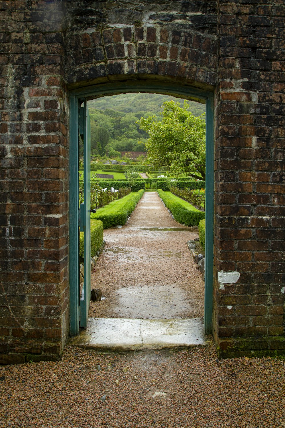 parede de tijolo marrom com campo de grama verde