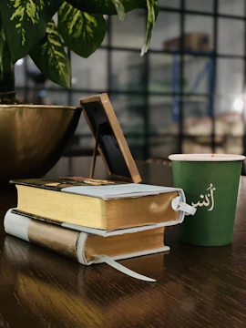 A peaceful corner with a Quran resting on a wooden stand beside a small green plant.