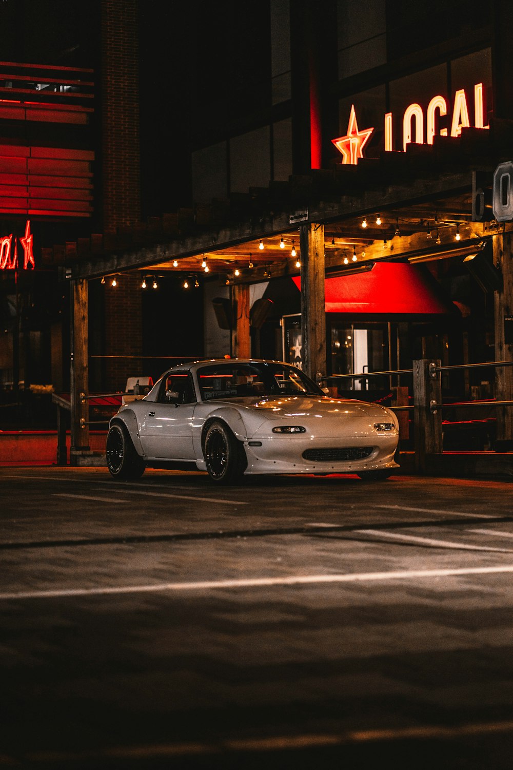 white porsche 911 parked in front of store