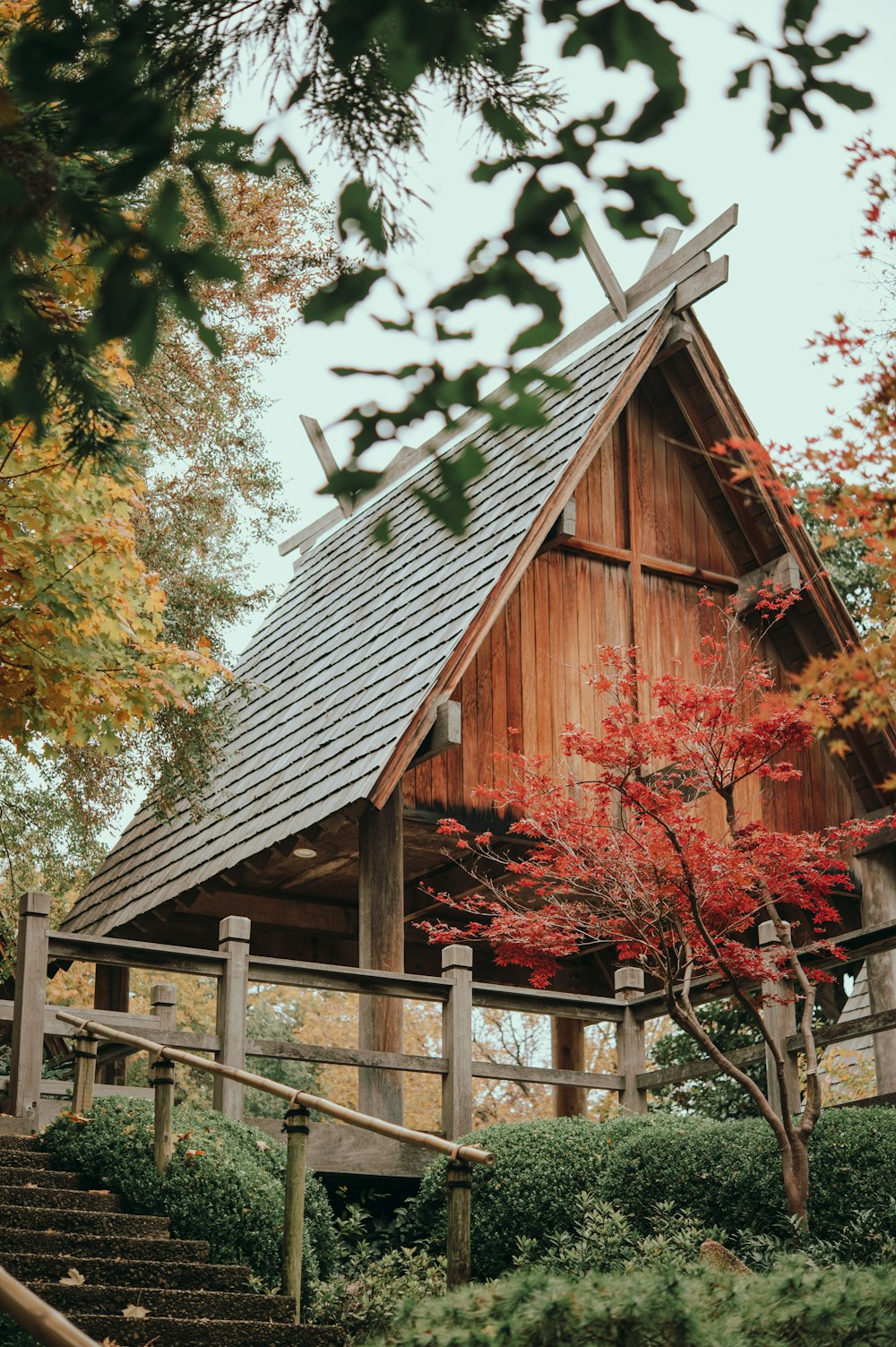 brown wooden house near green trees during daytime