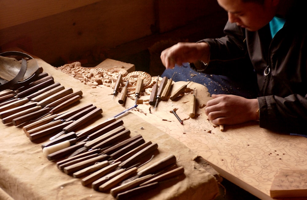 persona che tiene l'attrezzo manuale in legno marrone