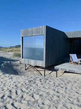 gray wooden house on brown sand during daytime