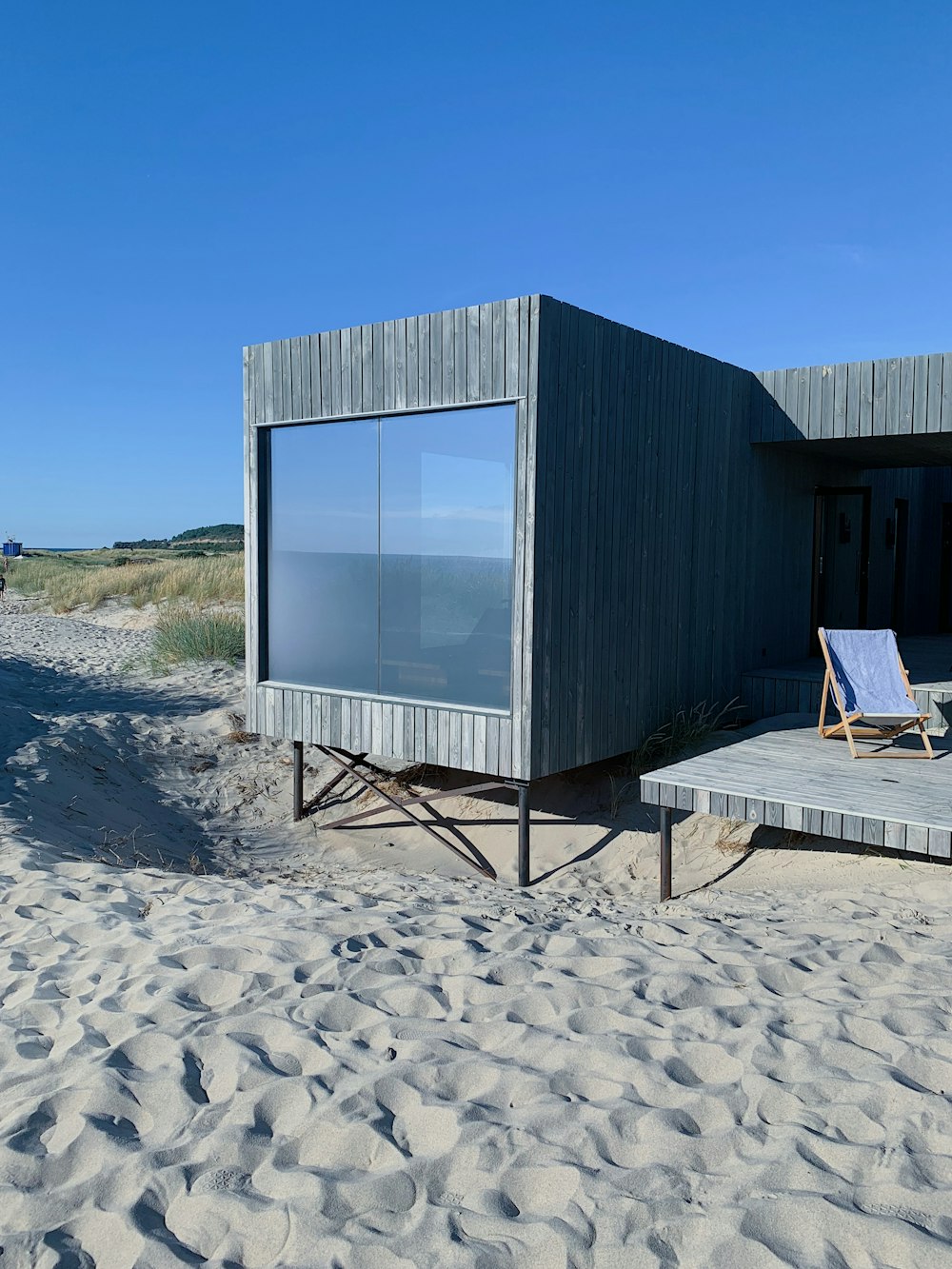 gray wooden house on brown sand during daytime