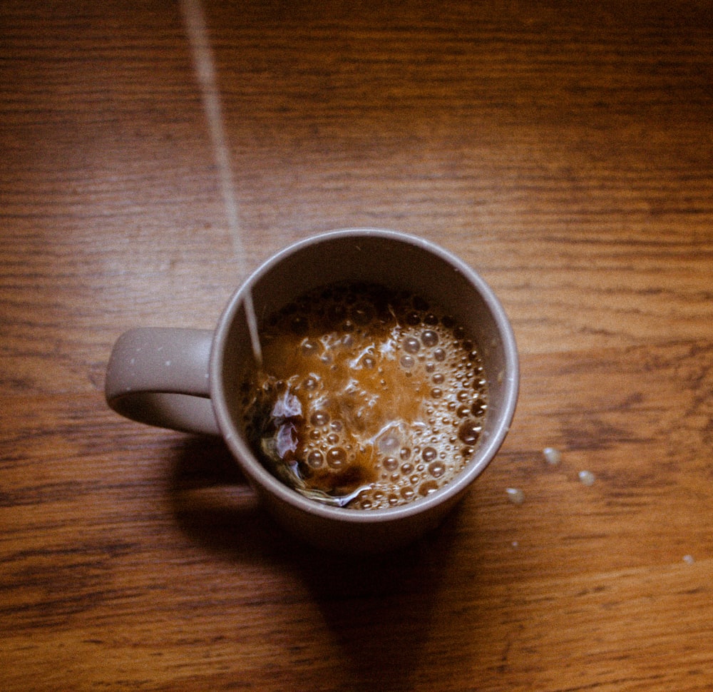 white ceramic mug with brown liquid