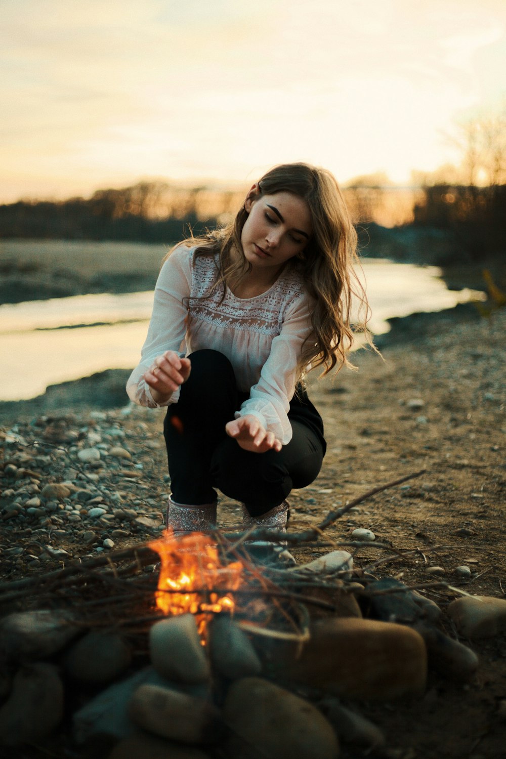 woman in white hoodie holding fire
