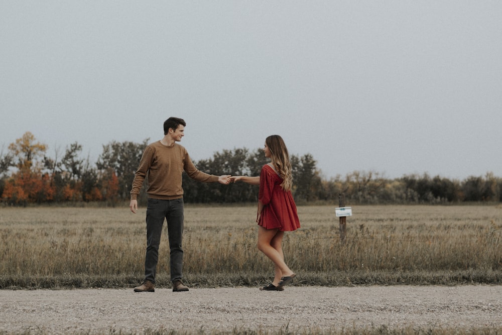 man and woman walking on dirt road during daytime
