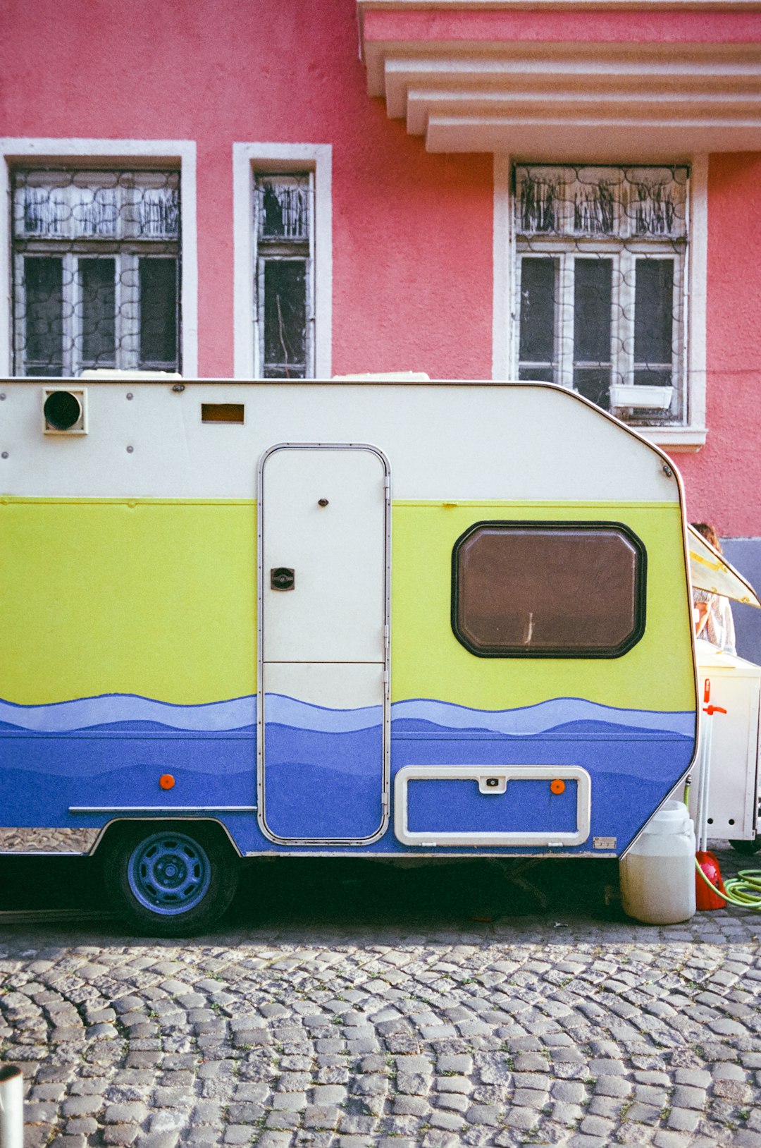 blue white and red van parked beside red and white concrete building