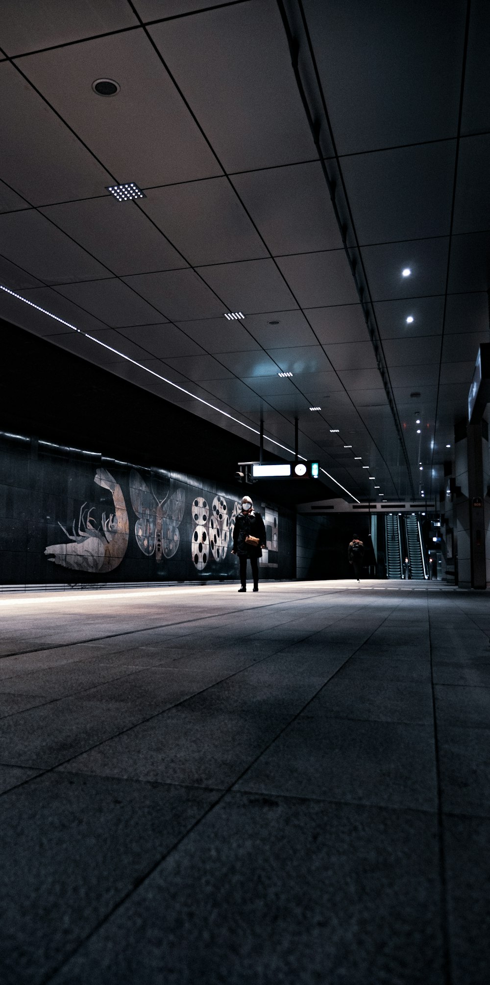 man in black jacket standing near wall