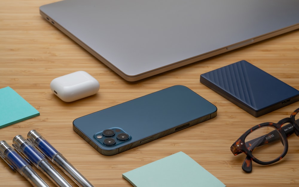 macbook pro beside apple magic mouse and apple magic mouse on brown wooden table