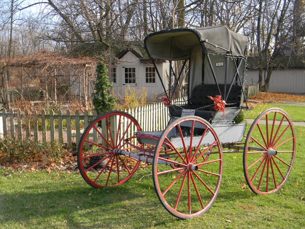 brown wooden carriage on green grass field during daytime