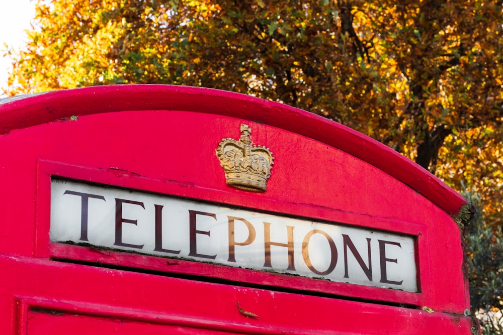 a red telephone booth with a crown on top