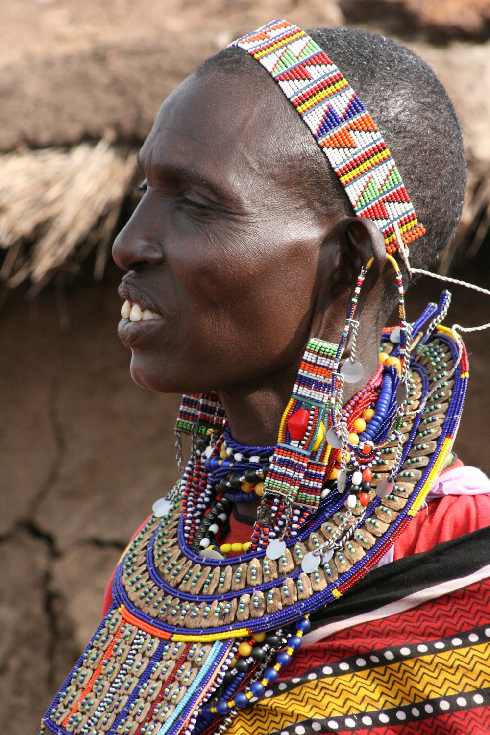 woman in red blue and yellow beaded necklace