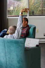 man in red and black plaid dress shirt sitting on green chair