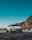 White SUV parked on a scenic mountain road with clear blue skies