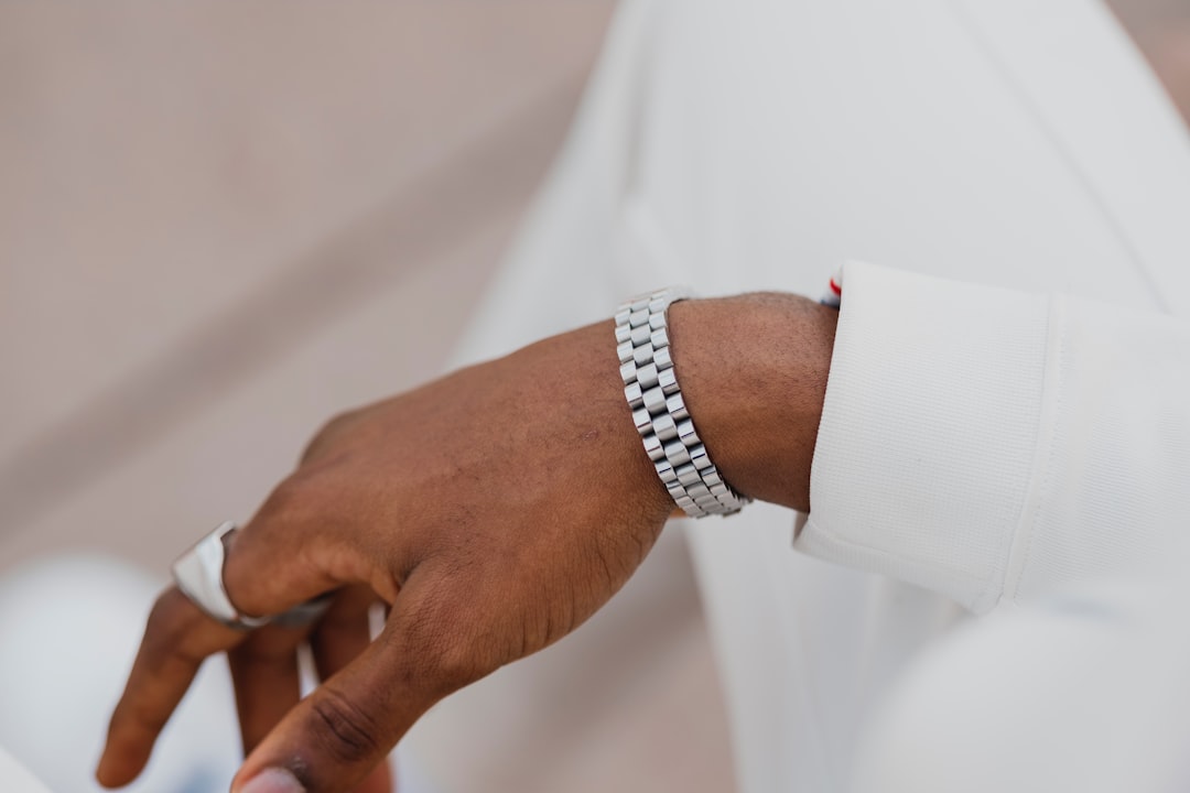 person wearing silver link bracelet watch
