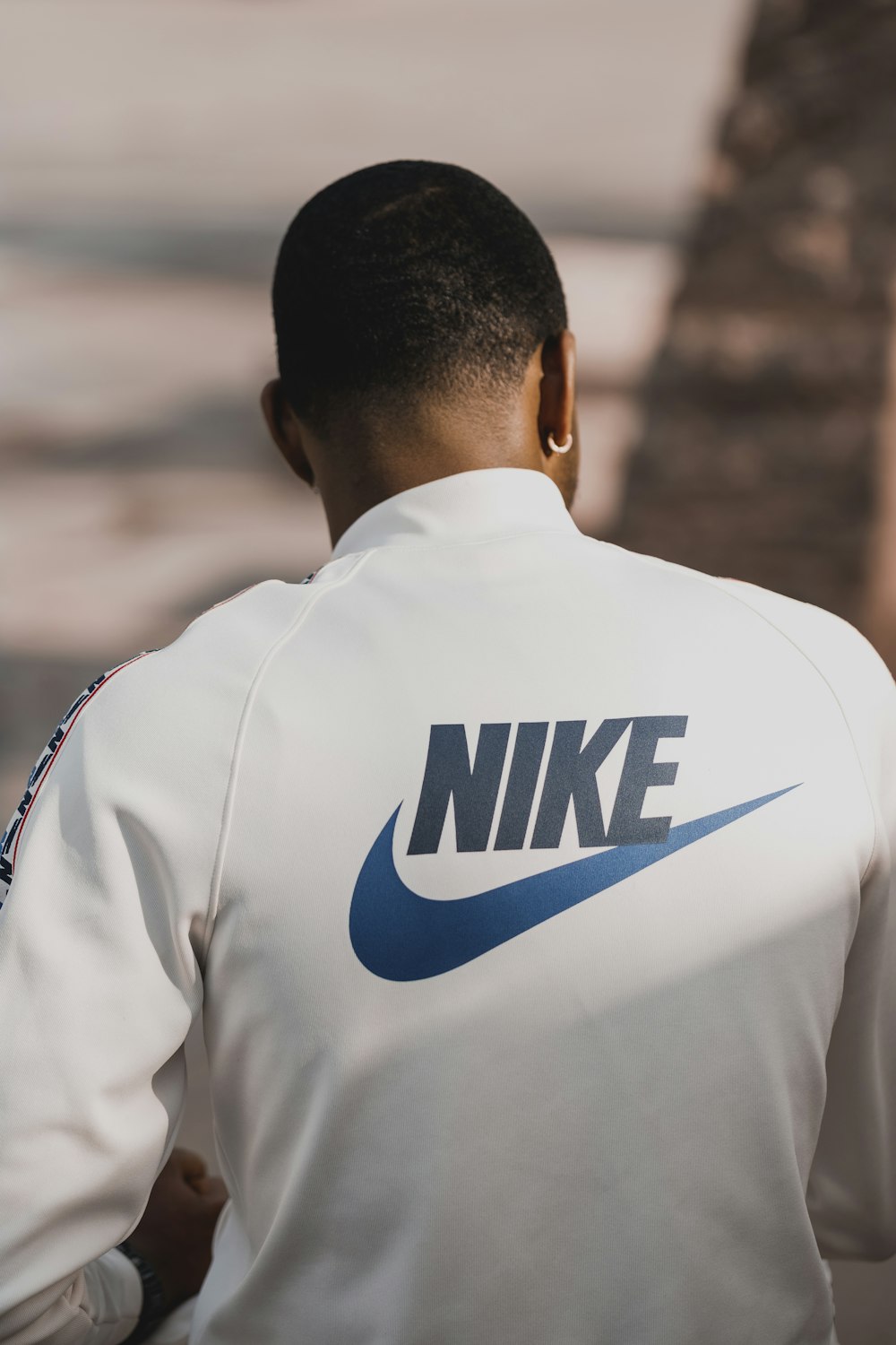 Hombre con camisa Nike blanca y azul