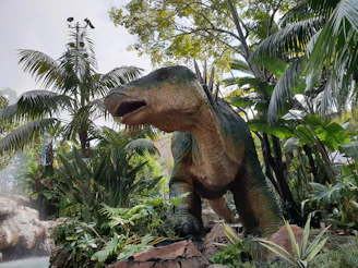 green and brown dinosaur statue