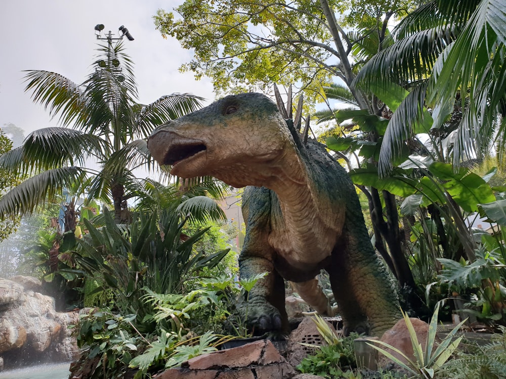 green and brown dinosaur statue