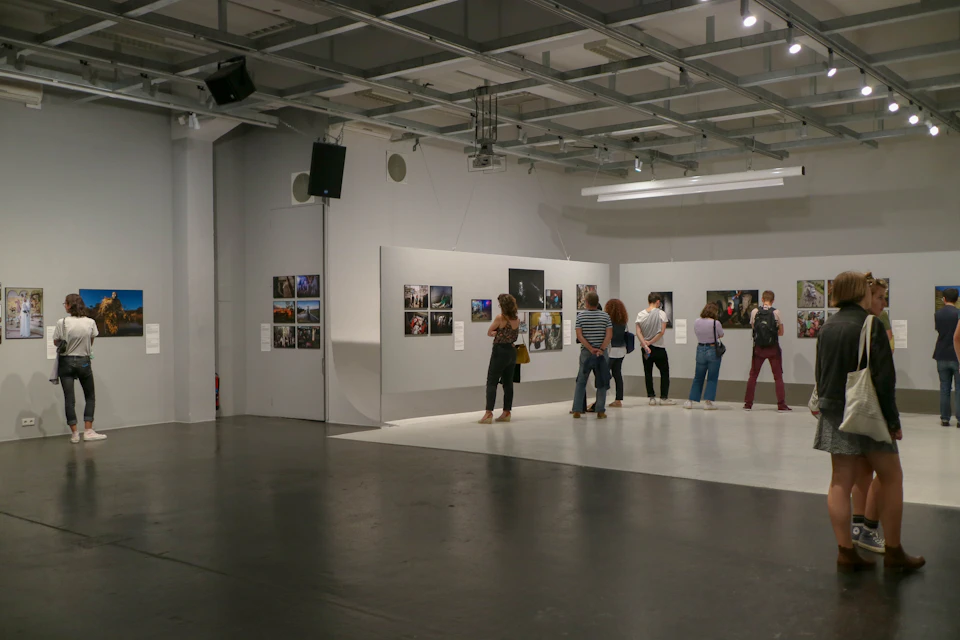 Aula pameran dengan foto dan lukisan di dinding