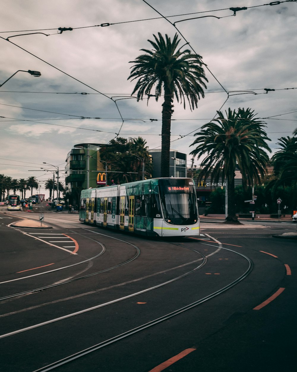 green and white tram on road during daytime