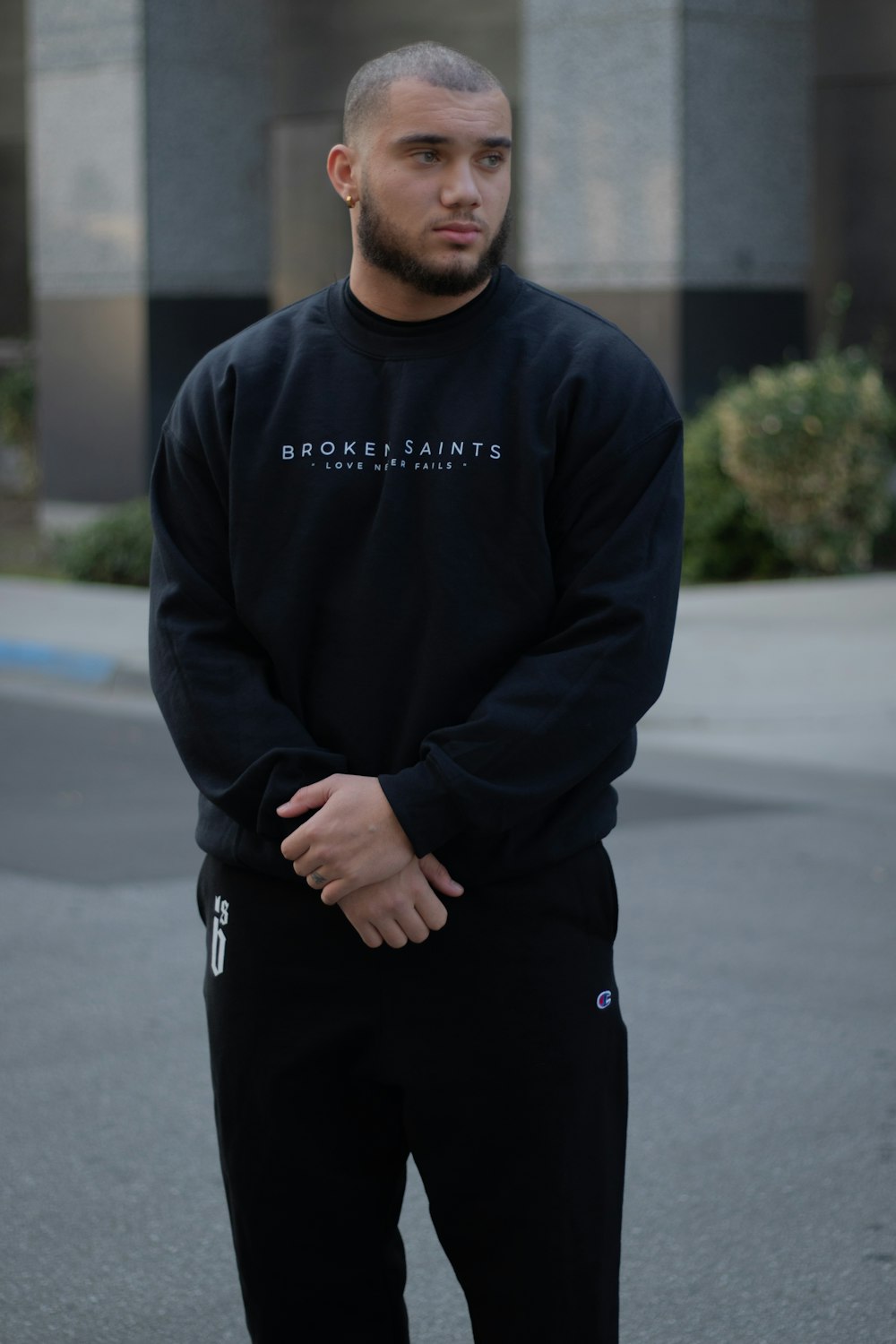 man in black sweater standing on road during daytime