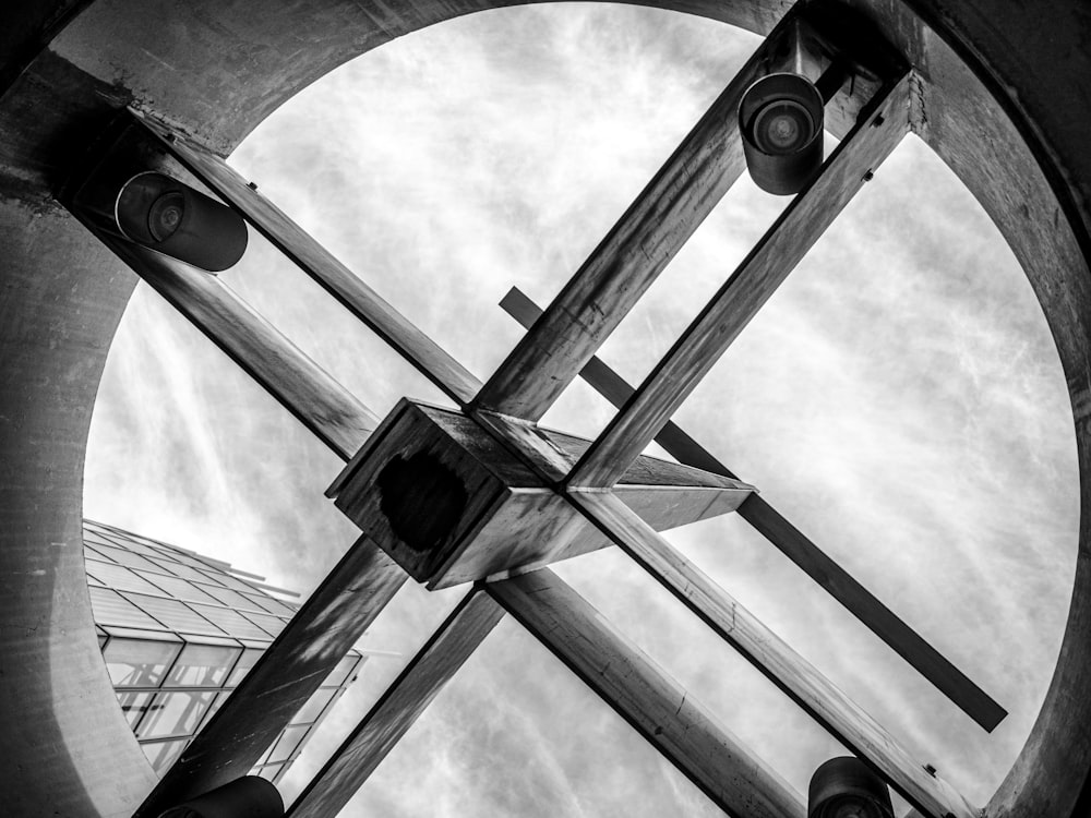 grayscale photo of cross under cloudy sky