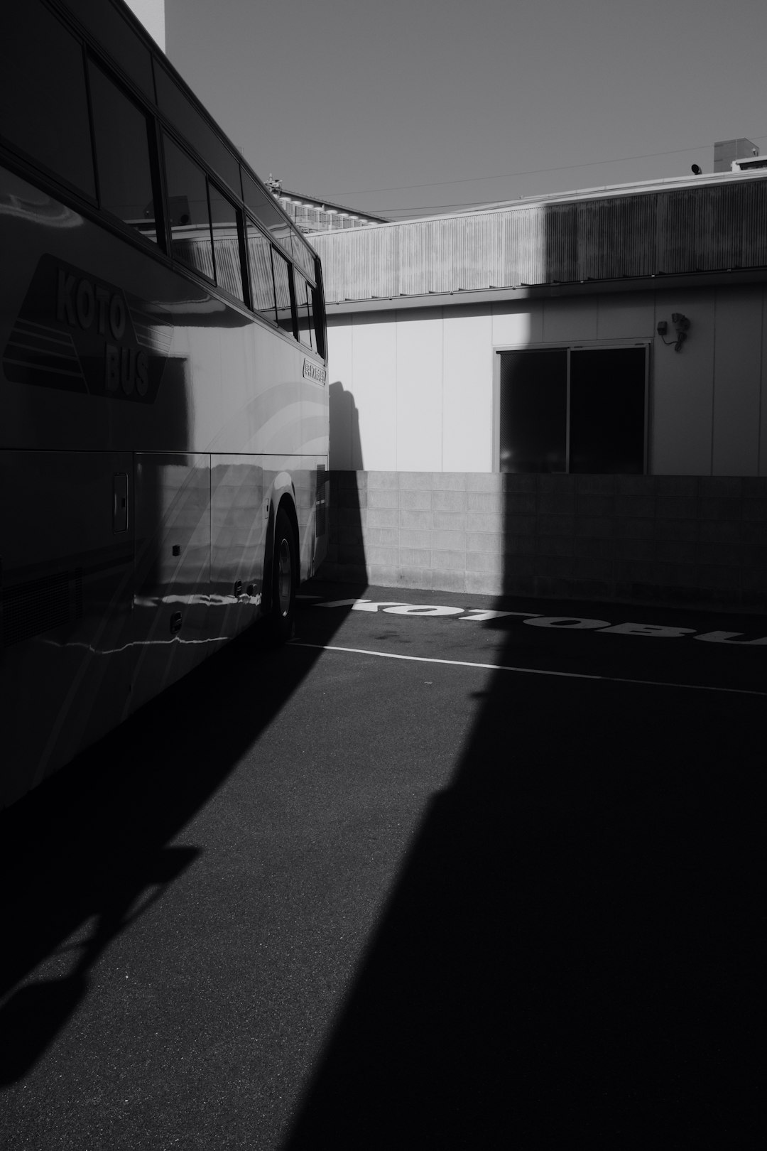 grayscale photo of a bus in front of a building