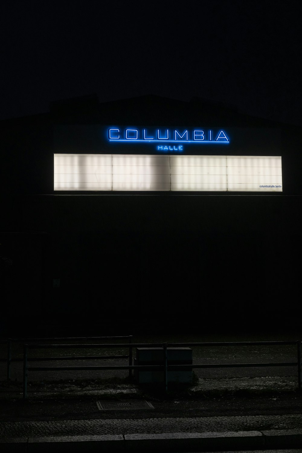 a building lit up at night with the word columbia on it
