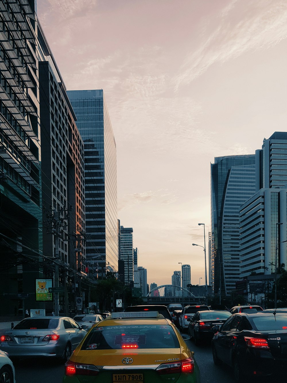 cars on road between high rise buildings during daytime