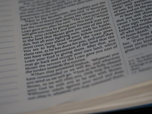 Close-up view of an open book with text. The text appears to be religious or biblical, as it references 'the LORD' multiple times.