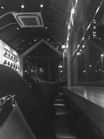 Interior of a sleek, dark-mode brunch café with matte black walls and charred wood accents, softly lit and inviting.