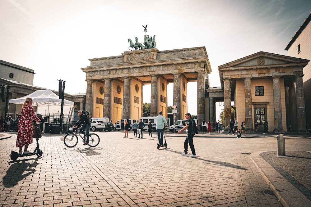 Menschen, die tagsüber auf dem Bürgersteig in der Nähe des beigen Betongebäudes spazieren gehen