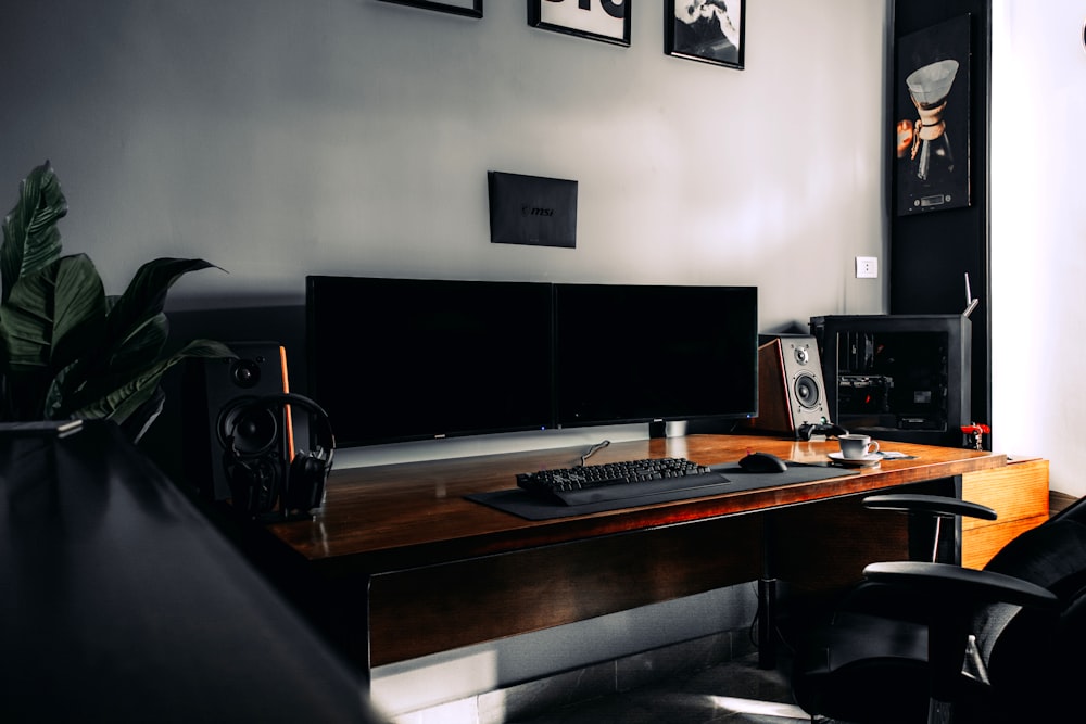 black flat screen computer monitor on brown wooden desk