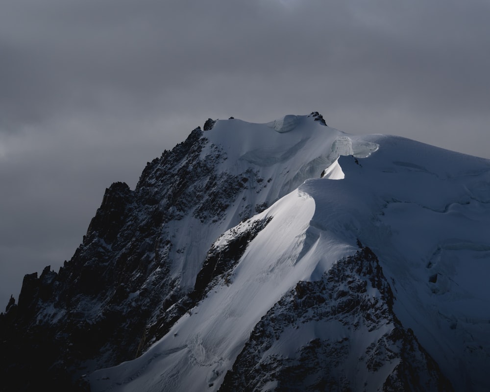 snow covered mountain under cloudy sky during daytime