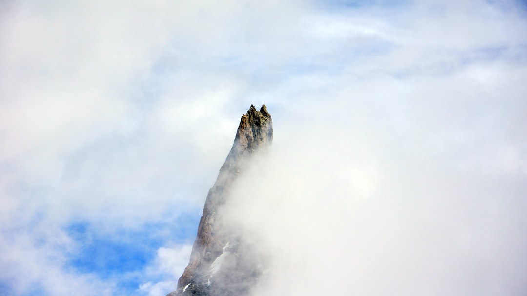 white clouds over brown mountain