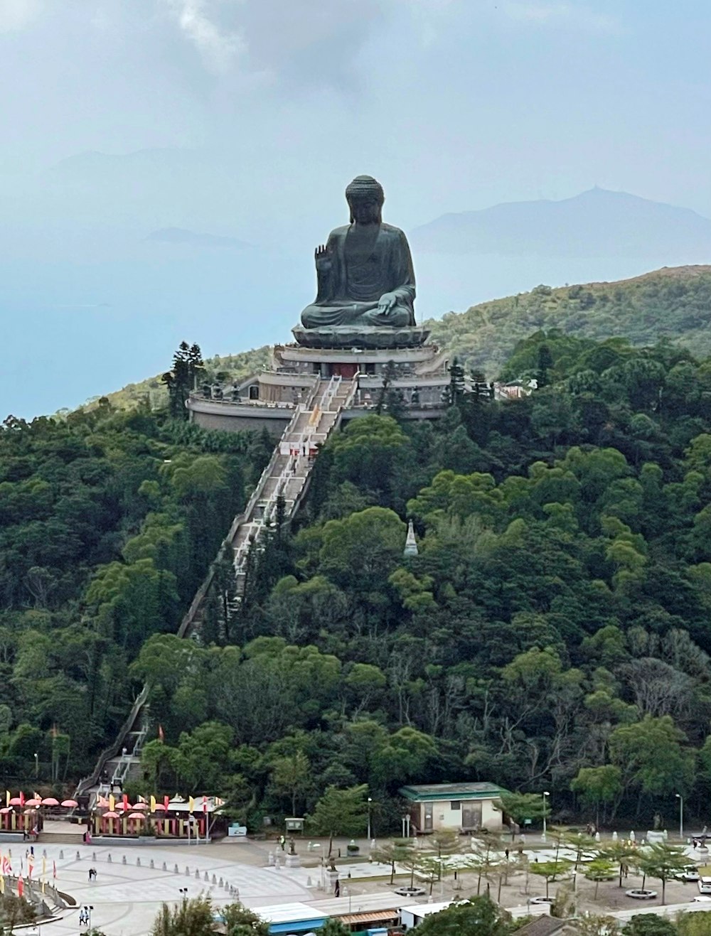 statue of man on top of mountain during daytime