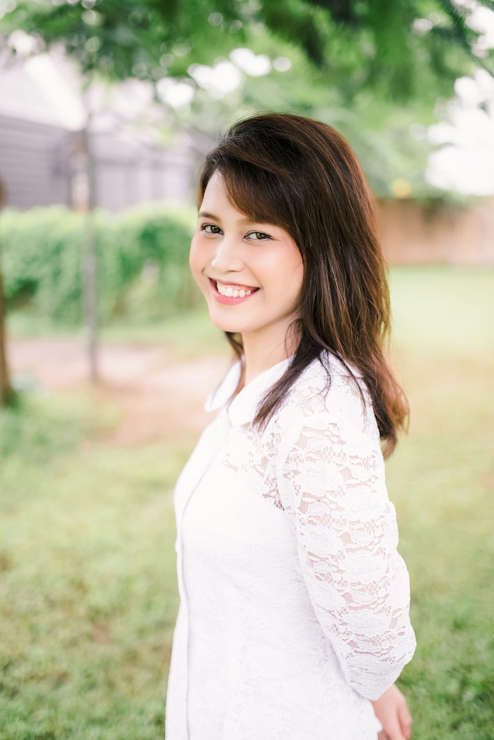 woman in white long sleeve shirt smiling
