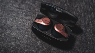 Wireless earbuds case wrapped in a subtle metallic skin with fine grid details, blending style and protection.