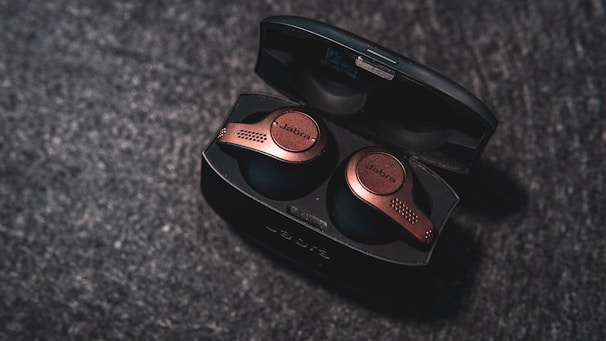 Wireless earbuds case wrapped in a subtle metallic skin with fine grid details, blending style and protection.