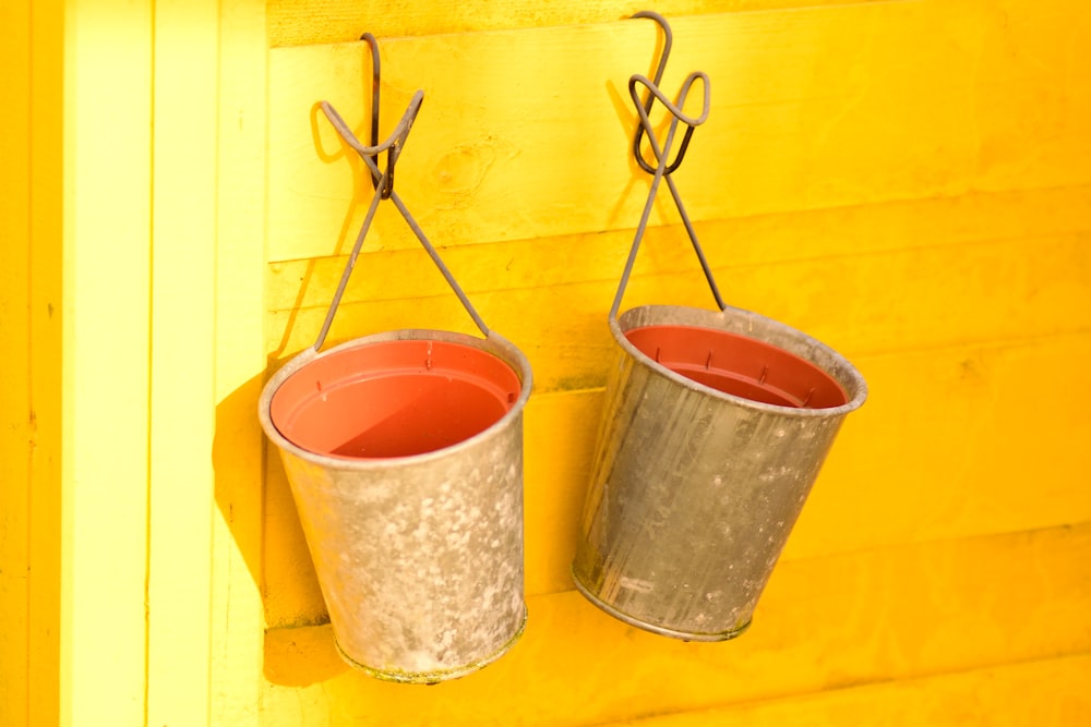 orange plastic bucket with brown wooden stick