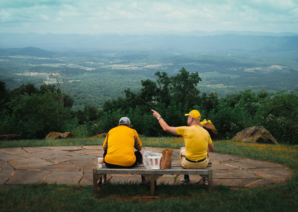 man and woman sitting on brown wooden bench during daytime