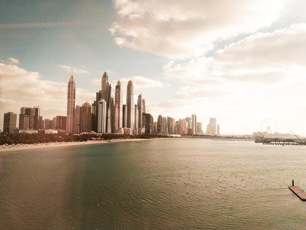 city skyline near body of water under white clouds during daytime