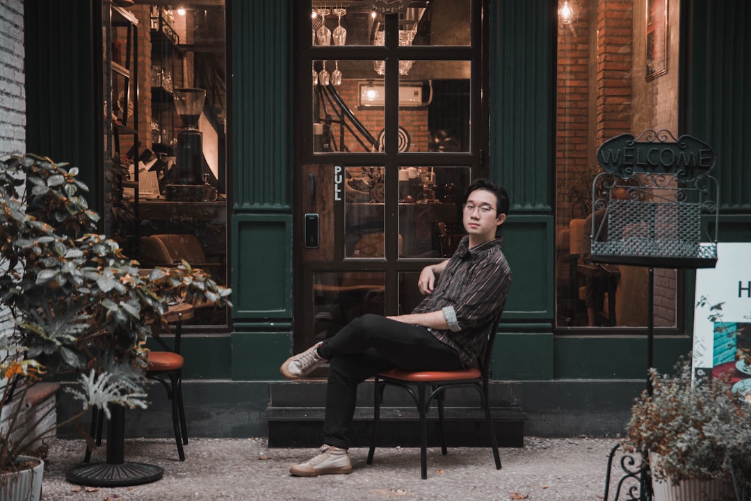 man in black jacket sitting on black chair