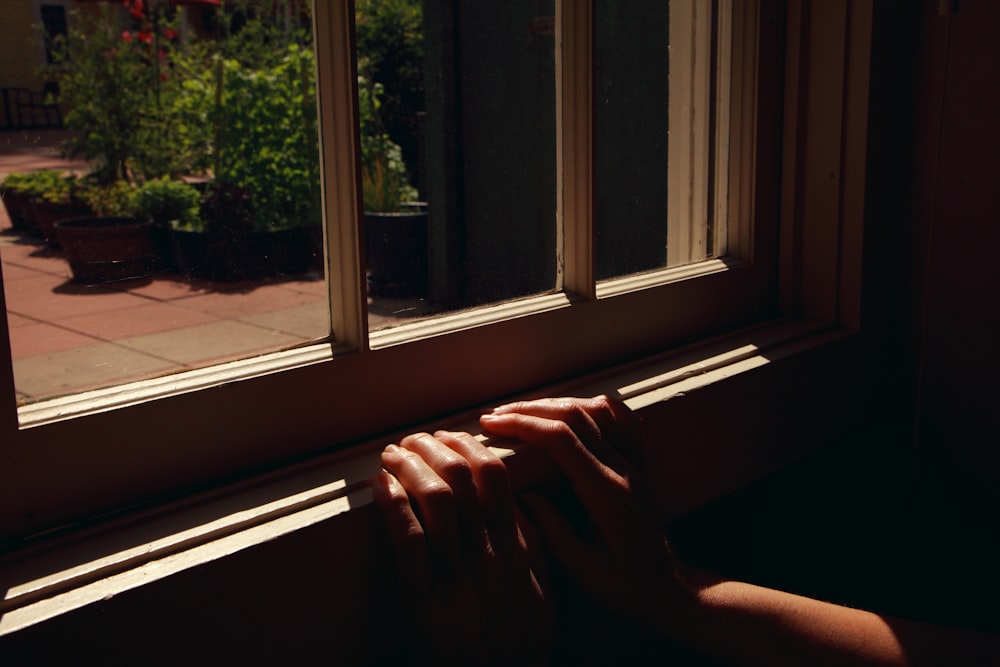 person holding white window frame