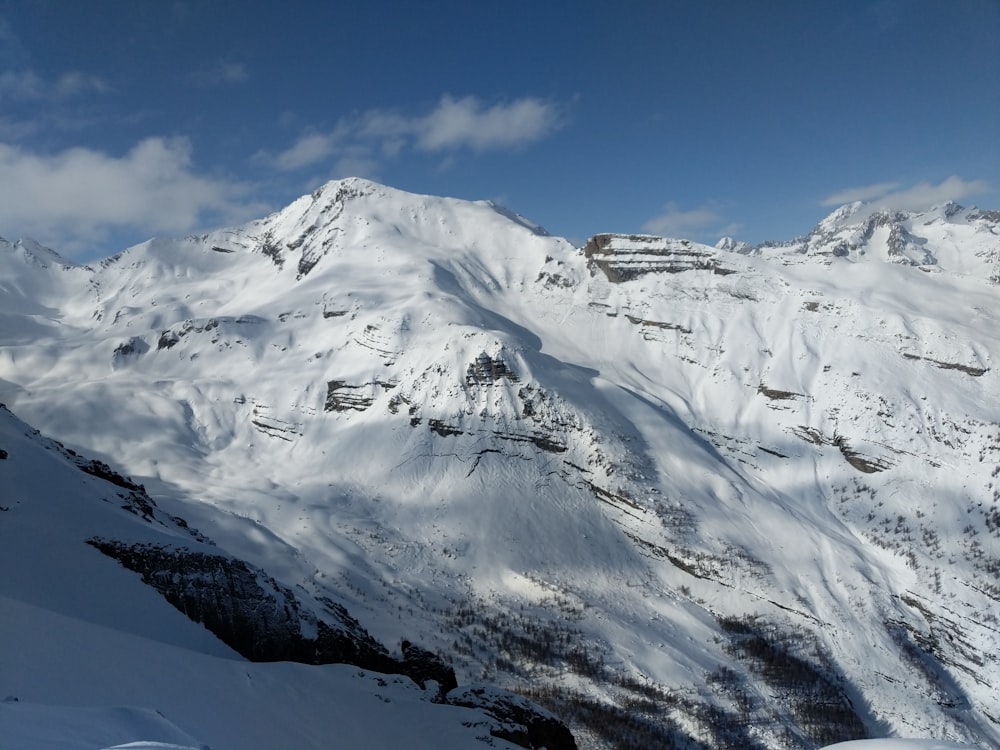 montanha coberta de neve sob o céu azul durante o dia