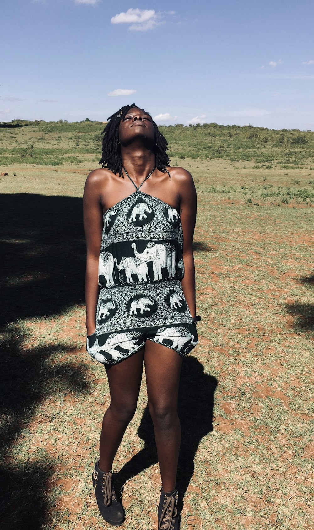 woman in black and white spaghetti strap dress standing on brown field during daytime