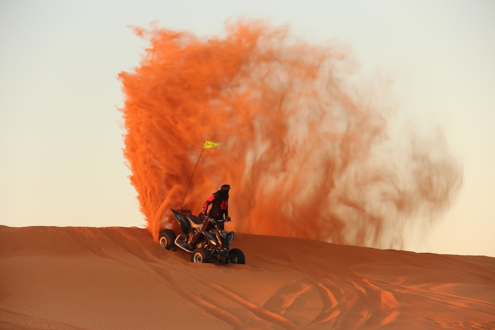 homem que monta a motocicleta na areia marrom