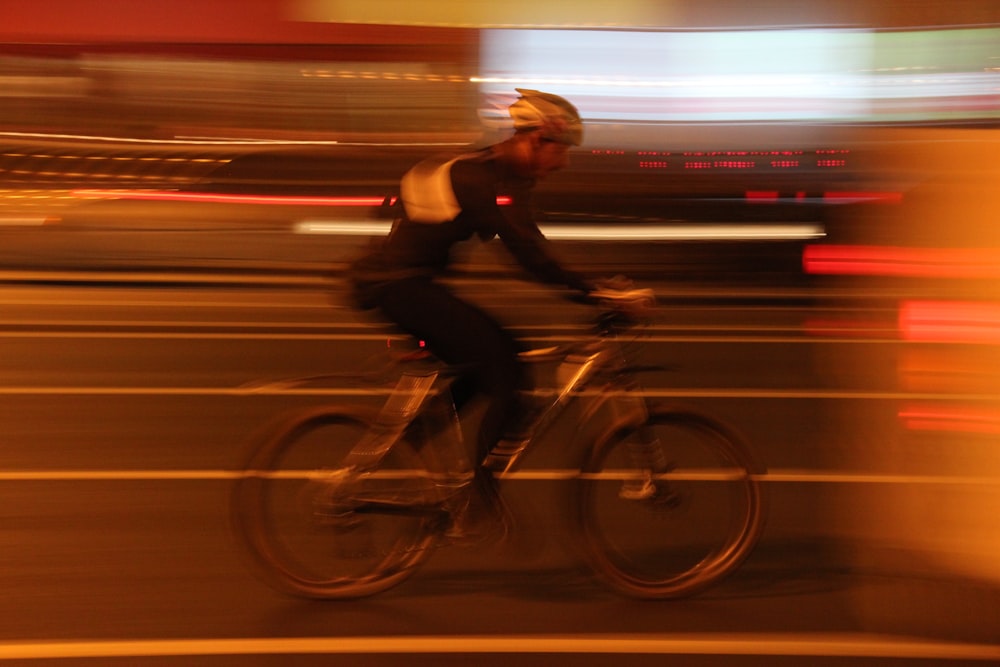 time lapse photography of man riding bicycle